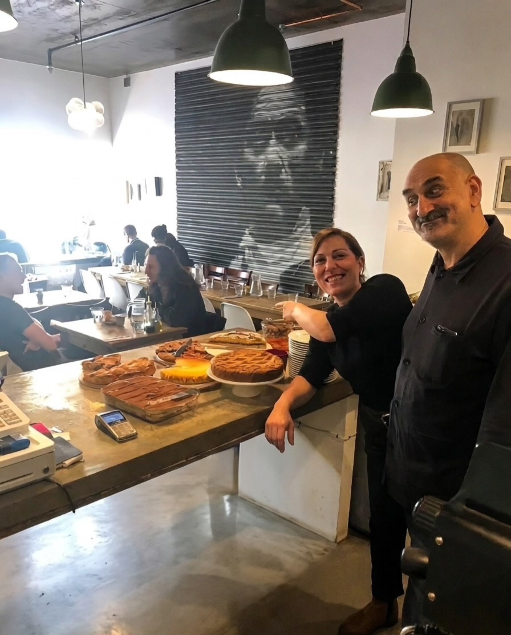 Antonio and Annarita smiling behind the counter at Fazenda
